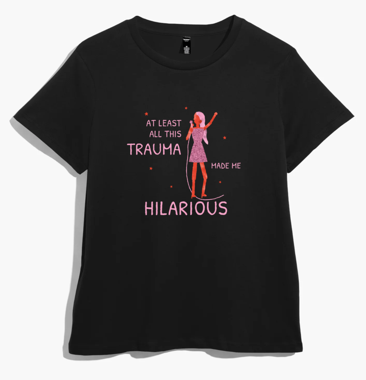 Black women’s t-shirt with a pink-haired singer in a glittery dress and “at least all this trauma made me hilarious” in pink lettering