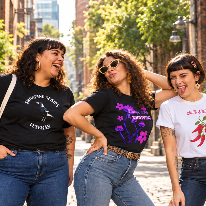 Friends laughing in a laneway wearing Odd Little Unit tees